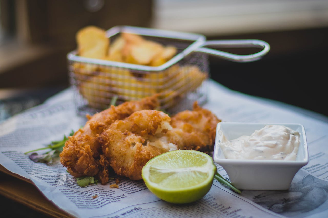 about-03 Close-up of fried fish and chips with tartar sauce and lime, perfect for food lovers.