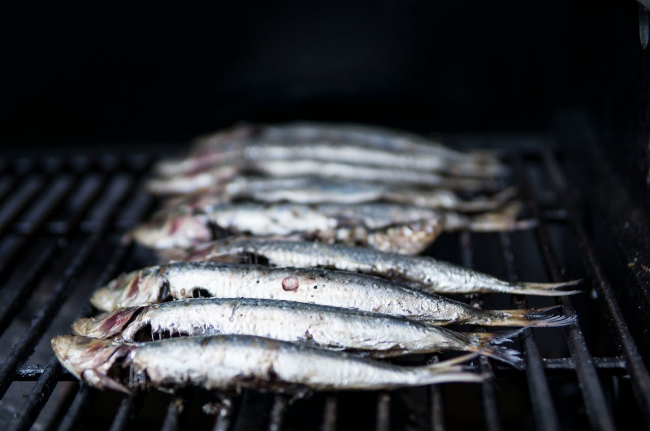 menu-02 Close-up of sardines being grilled, perfect for healthy seafood cuisine.